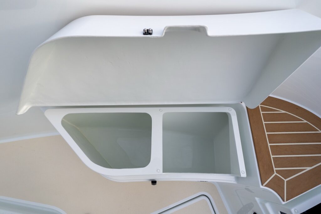 Open integrated deck storage compartment on a Targa 27.2 Coupe, showing a molded bin with smooth gelcoat finish beneath a flush-mounted deck hatch.