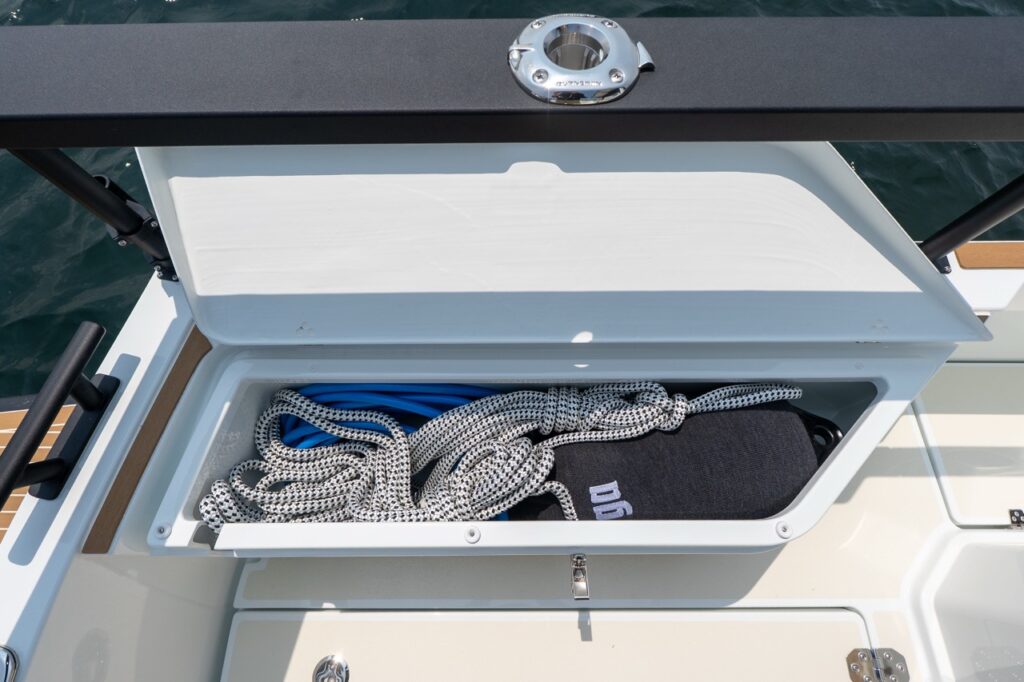 Open aft cockpit storage locker on a Targa 32 showing neatly coiled dock lines and gear beneath the aft rail.