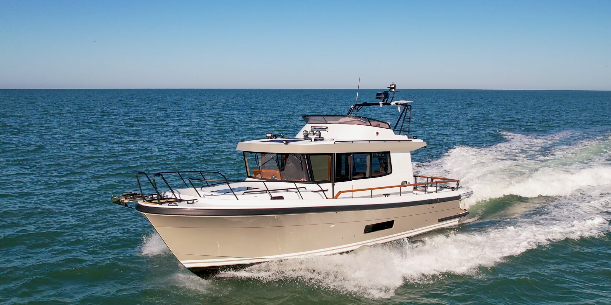 Targa 41 pilothouse cruiser running offshore in calm blue water, showcasing all-weather performance and protected walkaround decks