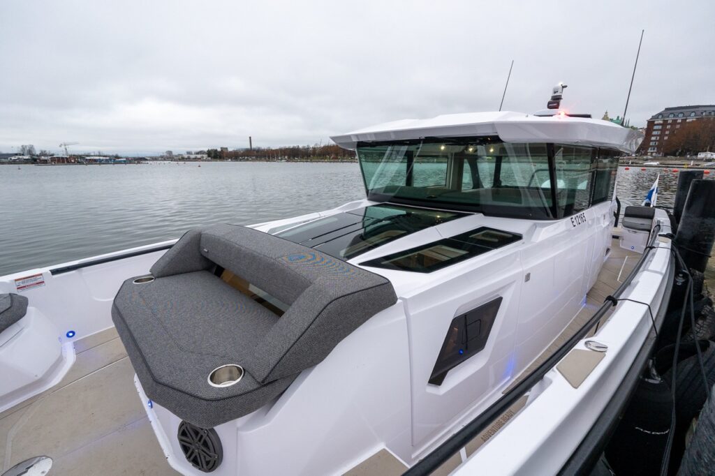 Looking aft from the forward deck of the Axopar 38, showing the forward bench seat, the roof of the forward cabin, and the pilothouse behind it.