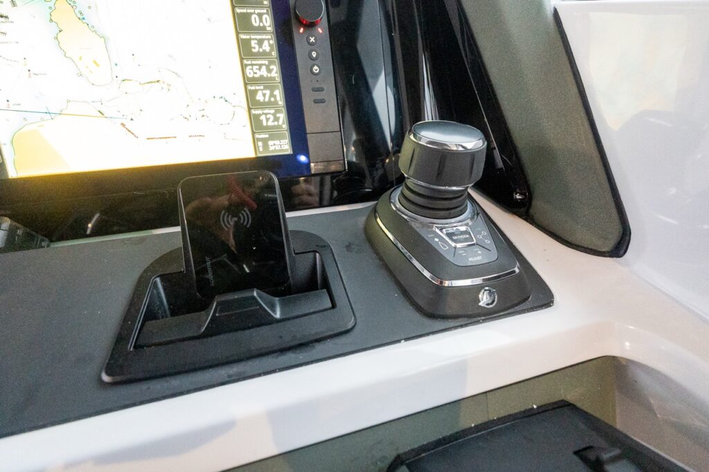 Close-up of the Mercury Joystick Piloting (JPO) control at the Axopar 38 helm, positioned beside the Multi Function Display (MFD), showing the intuitive joystick used for precise low-speed maneuvering and docking.