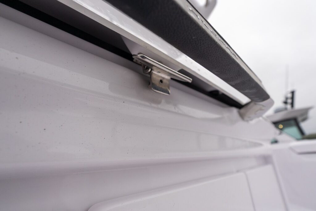 Close-up of stainless steel latch securing the lid on the Axopar 38 aft wet bar, showing marine-grade hardware and build detail.