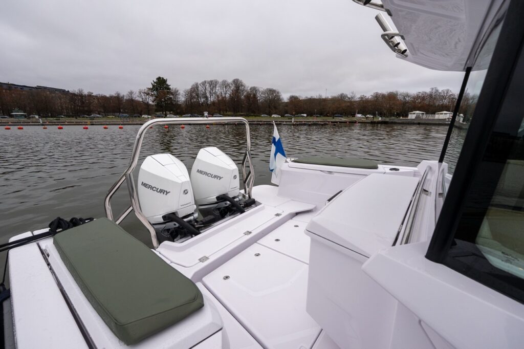 Axopar 38 aft wet bar located behind the pilot house, showing twin Mercury outboards, aft deck layout, and integrated storage.