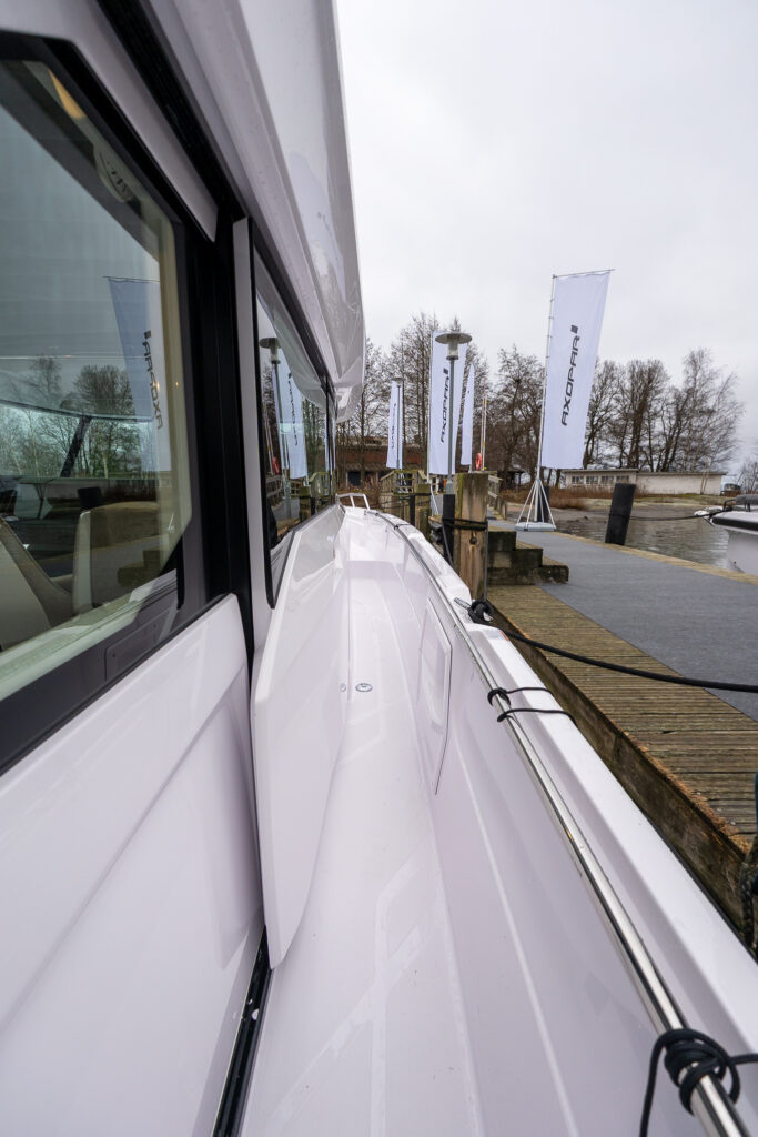 Starboard side walkaround sidedeck on the Axopar 38, looking forward along the pilothouse toward the bow.