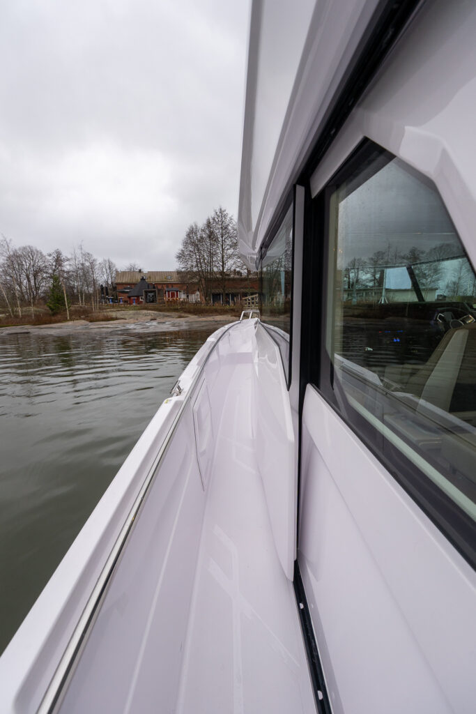 Port side walkaround sidedeck on the Axopar 38, looking forward along the hull toward the bow.