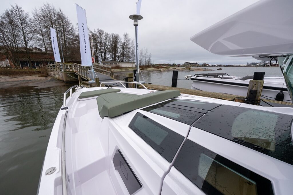 Axopar 38 forward deck looking toward the bow, showing the forward sun lounge, bow seating, and skylights over the forward cabin.