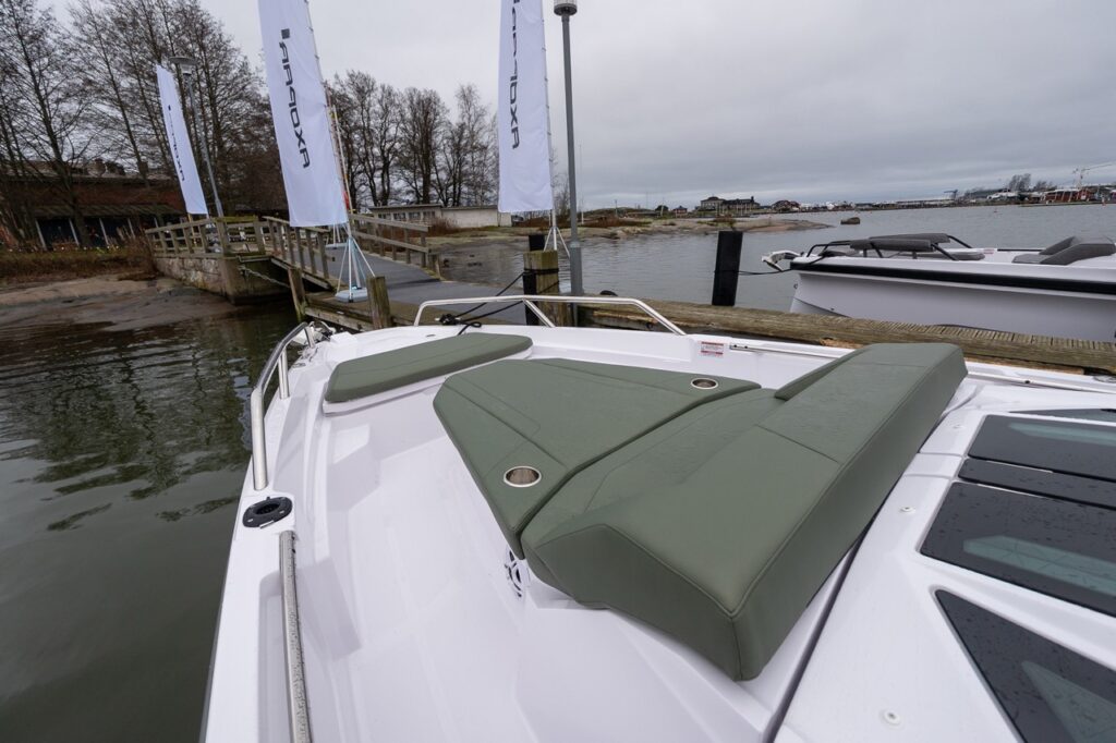 Axopar 38 forward deck sun lounge with hunter green upholstery and split sunbed cushions, shown at dock during Axopar 38 media day in Finland.