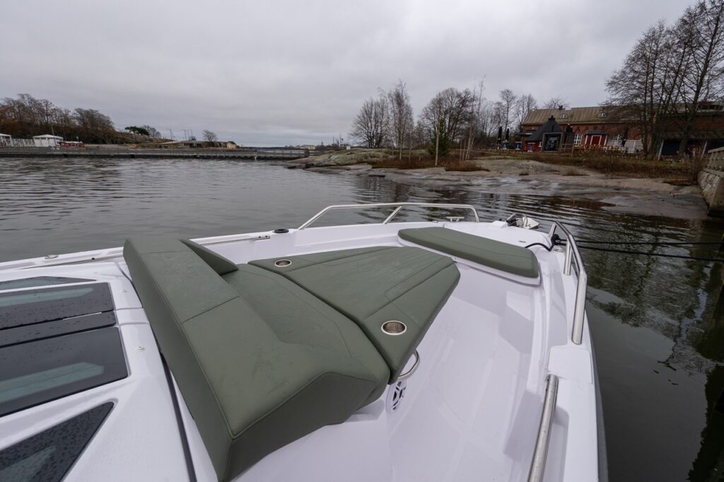 Axopar 38 forward sunbed with hunter green upholstery, showing the angled sun lounge and bow walkway during Axopar 38 media day in Finland.