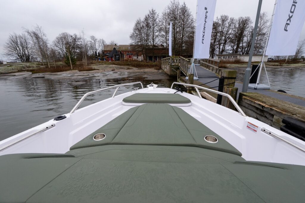 Axopar 38 forward sunbed and bow seating area with hunter green upholstery, shown dockside during Axopar 38 media day in Finland.