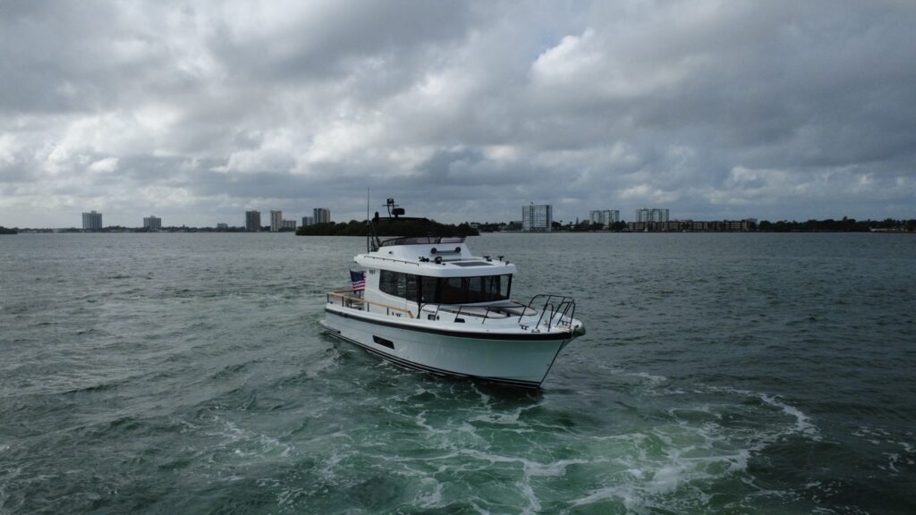 Targa 41 cruising in Florida waters from a forward port angle, showing the enclosed pilothouse, flybridge, and bow underway.