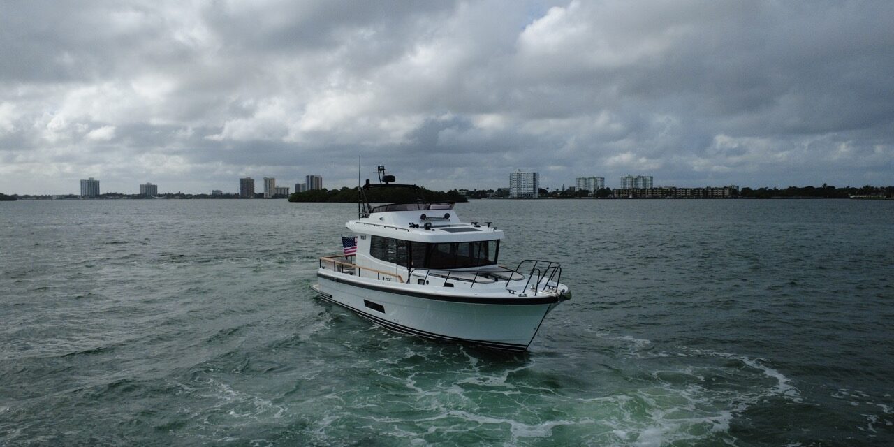 Targa 41 cruising in Florida waters from a forward port angle, showing the enclosed pilothouse, flybridge, and bow underway.