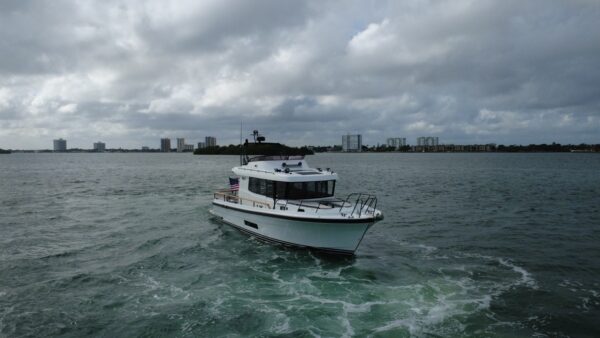Targa 41 cruising in Florida waters from a forward port angle, showing the enclosed pilothouse, flybridge, and bow underway.