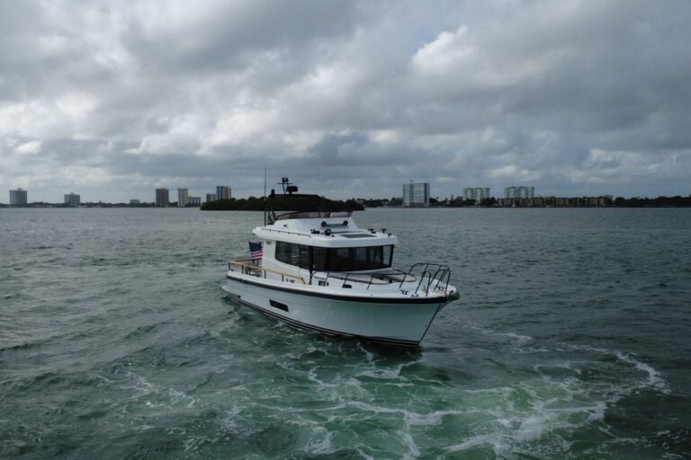 Targa 41 cruising in Florida waters from a forward port angle, showing the enclosed pilothouse, flybridge, and bow underway.
