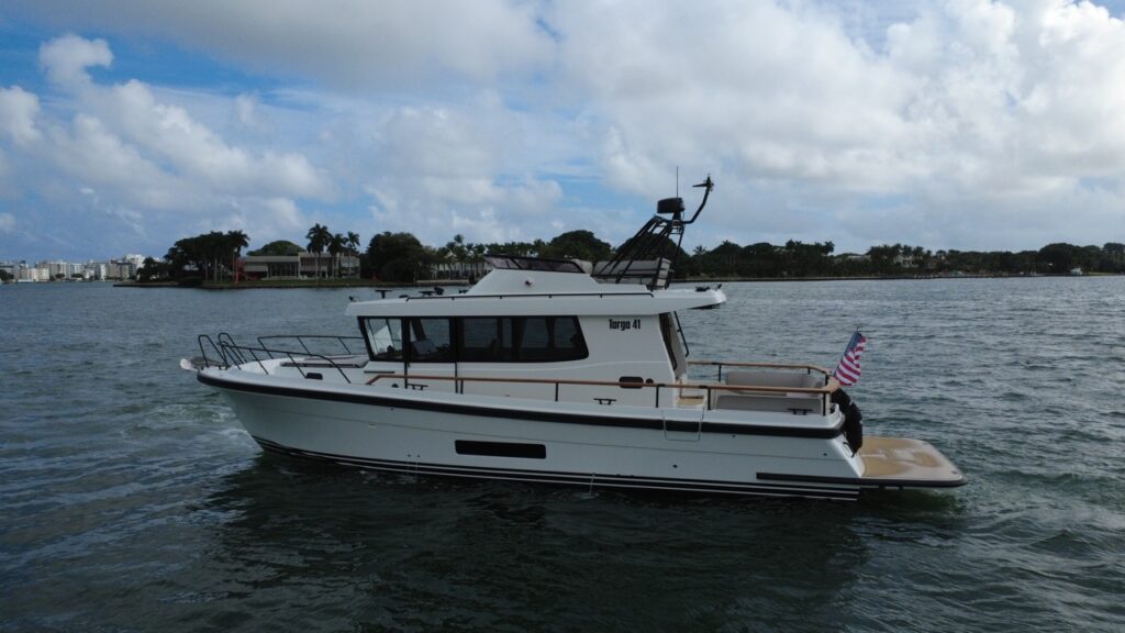 Port-side view of a Targa 41 underway in Florida, showing the pilothouse, flybridge, walkaround side decks, and extended swim platform.