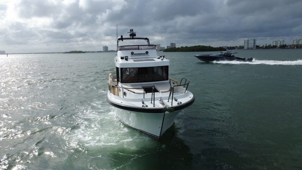 Targa 41 cruising in Florida waters, viewed head-on with the pilothouse and bow rails visible under overcast skies.