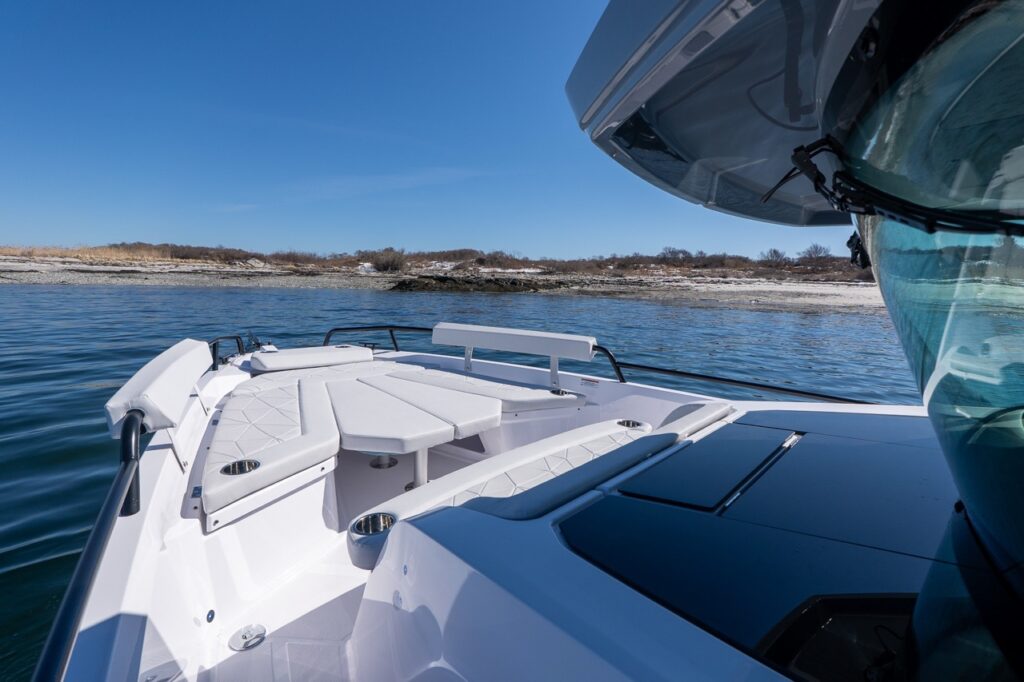Axopar 29 bow lounge seating with table and Chalk upholstery viewed from the pilothouse