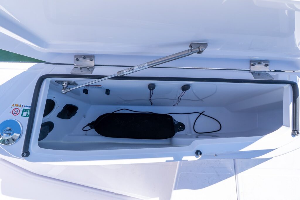 Axopar 29 side deck storage locker open showing built-in fender storage compartment