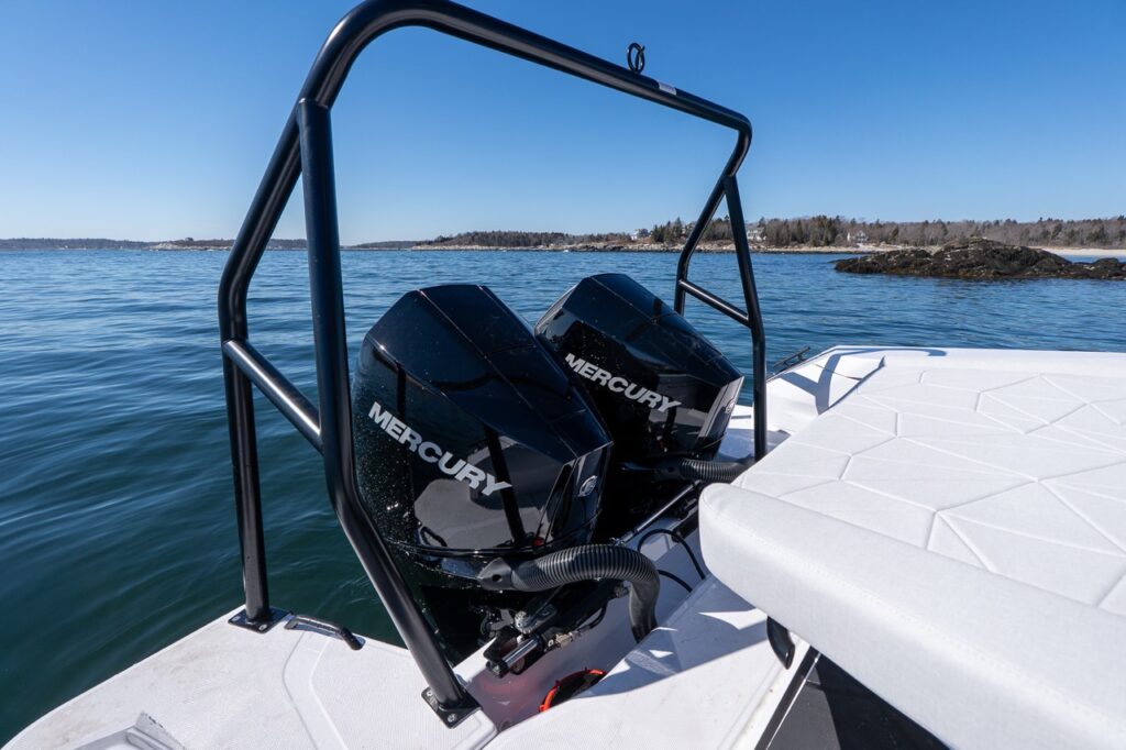 Axopar 29 aft deck sunbed with Chalk upholstery beside twin Mercury outboard engines