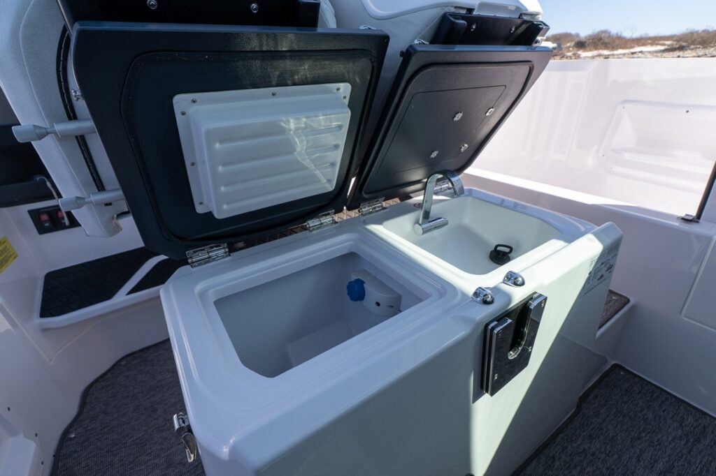 Axopar 29 wet bar module under helm seat with sink and refrigerated cooler compartment