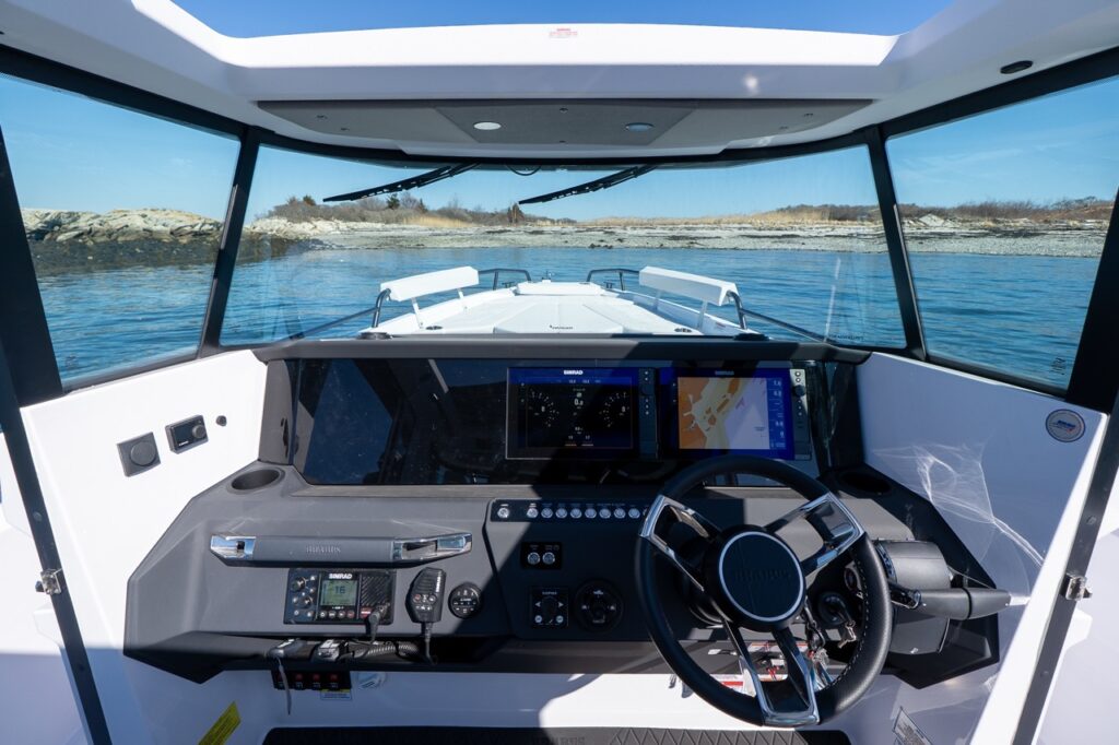 Axopar 29 XC Cross Cabin helm dashboard with dual Simrad displays and wide pilothouse windshield view