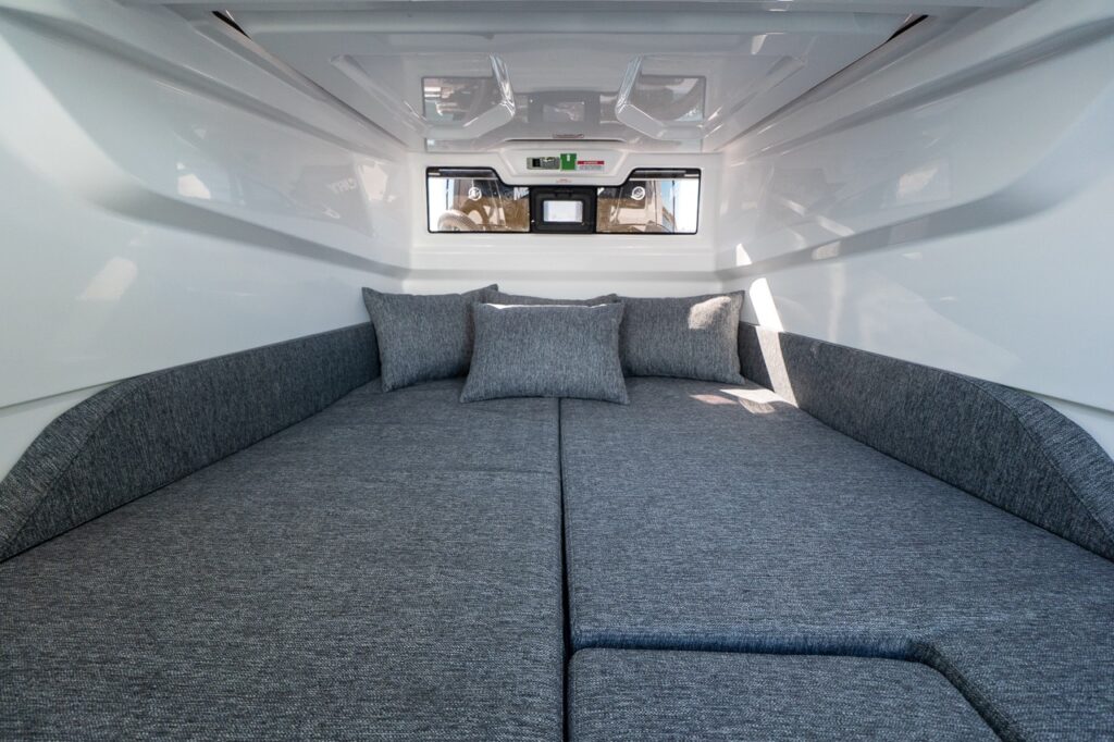 Spacious aft cabin double berth inside an Axopar 29 with grey cushions and overhead hatch