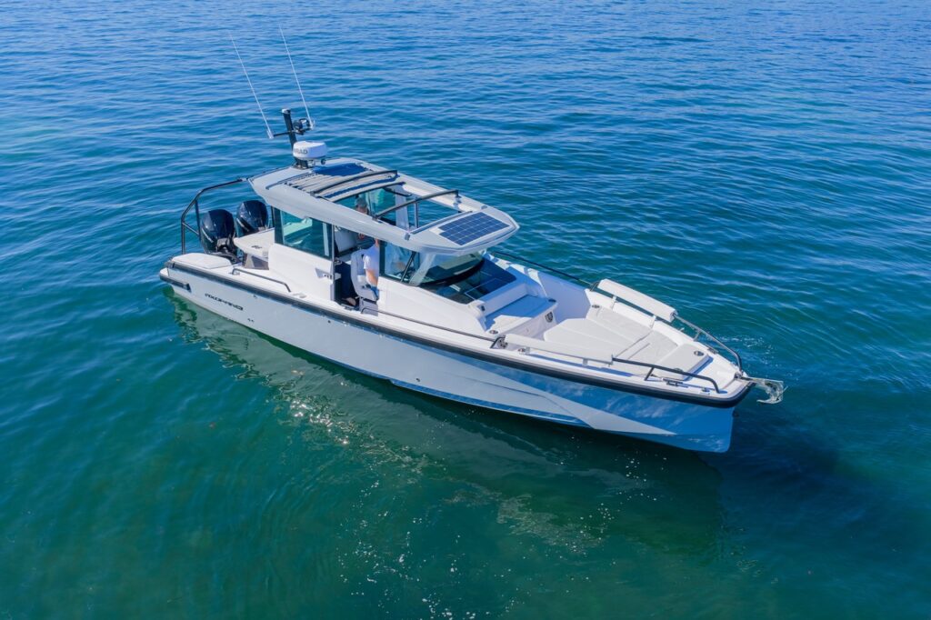 Aerial bow-quarter view of Axopar 29 Cabin with Platinum Gray hull, Chalk upholstery, and solar panel on pilothouse roof